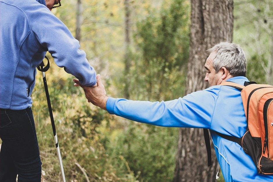 Supporting an older man on a hike