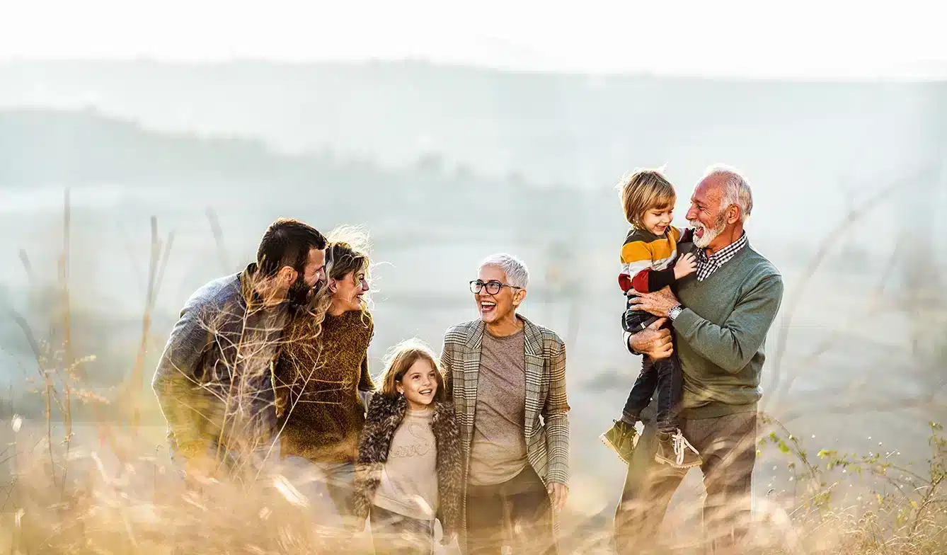 A multi-generational family playing in a field.