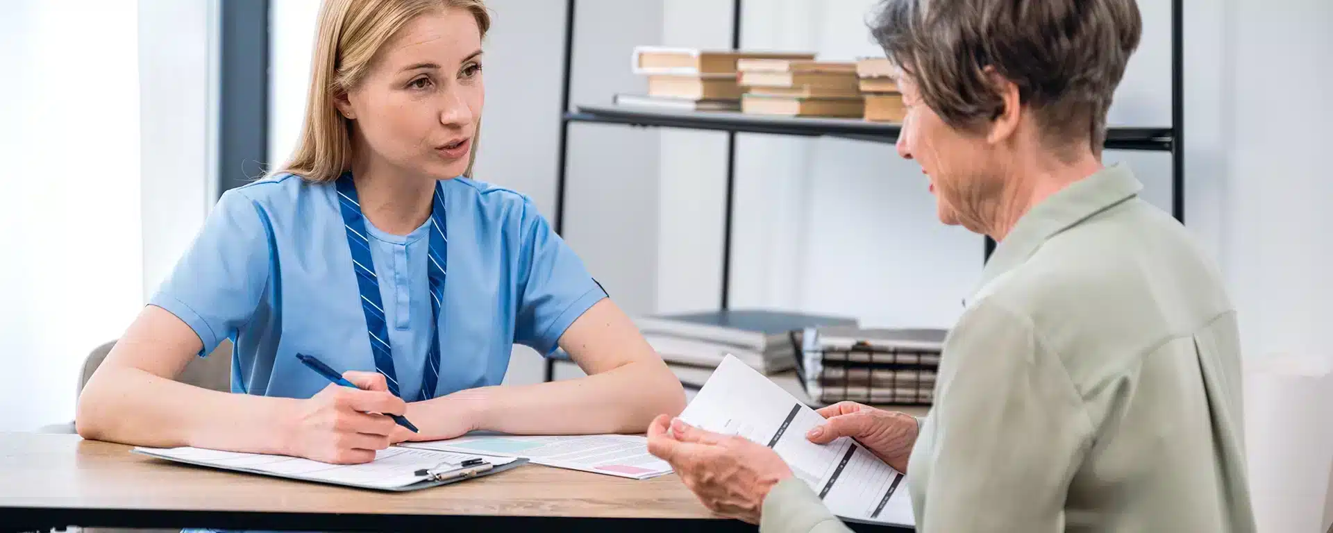 An elderly woman talking with an occupational therapist.